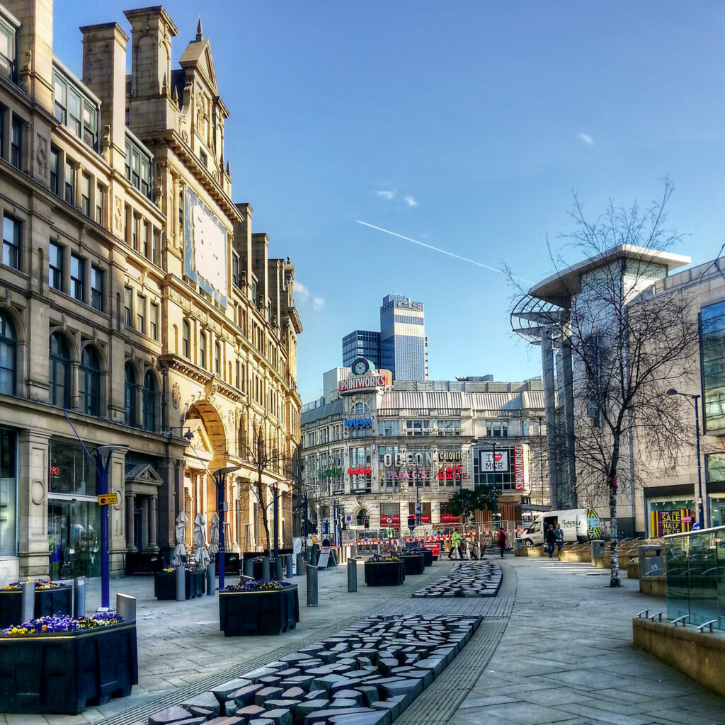 Shopping street in Manchester, with The Printworks in the background